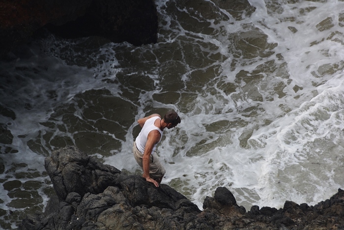 man on cliff overlooking water